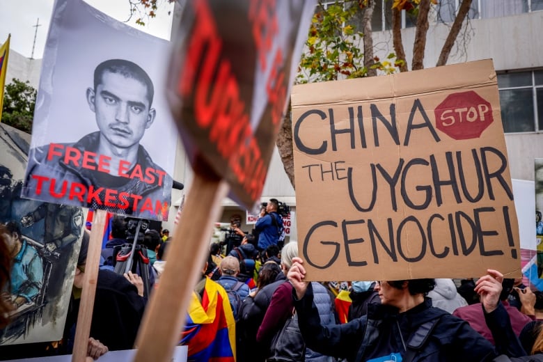 Protesters hold signs like, "Stop the Uyghur Genocide"