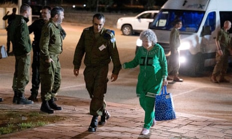 Released hostage Ruth Munder walks with an Israeli soldier shortly after her arrival in Israel