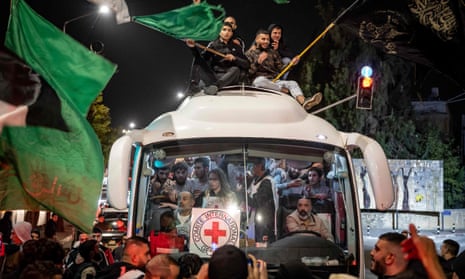 A crowd in Ramallah on the West Bank surrounds a Red Cross bus carrying Palestinian detainees released from Israeli jails on Sunday
