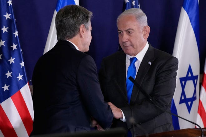 Israeli Prime Minister Benjamin Netanyahu shakes hands with US Secretary of State Antony Blinken during statements to the media inside The Kirya, which houses the Israeli Defense Ministry, after their meeting in Tel Aviv on October 12, 2023.